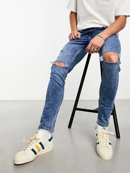 ASOS DESIGN skinny jeans with knee rips in mid wash blue