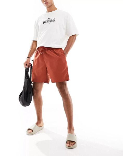 ASOS DESIGN swim shorts in mid length in rust