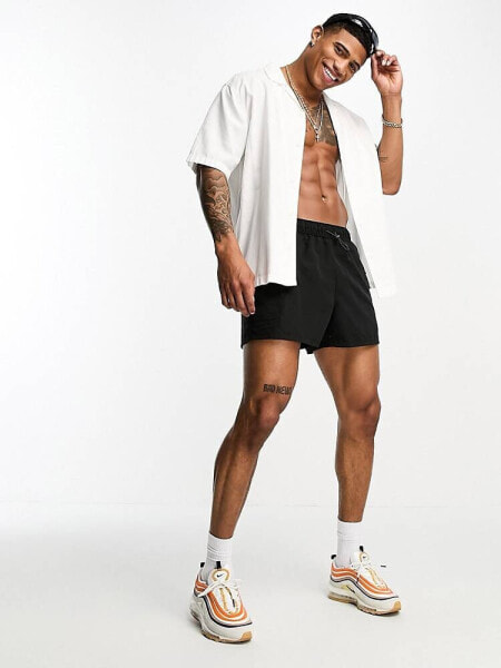 ASOS DESIGN swim shorts in short length with cargo pockets in black