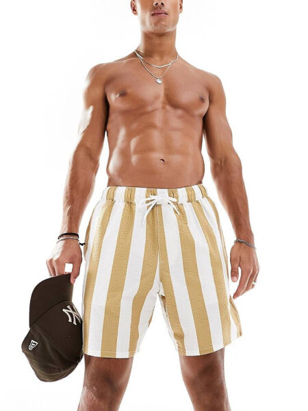 ASOS DESIGN seersucker swim shorts in short length in white and caramel stripe