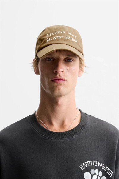 CAP WITH EMBROIDERED SLOGAN