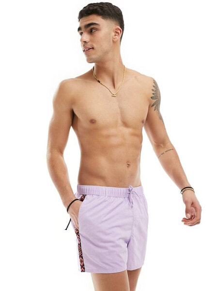 ASOS DESIGN swim shorts in short length with aztec side stripe in purple