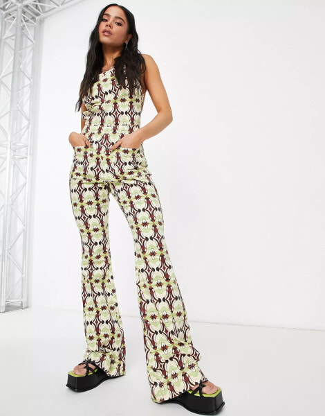 ASOS DESIGN – Neckholder-Jumpsuit mit ausgestelltem Bein und geometrischem Muster