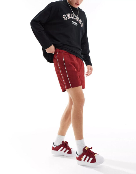 ASOS DESIGN slim nylon shorts with piping detail in burgundy