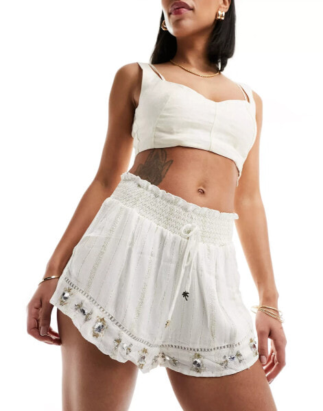 River Island – Strandshorts mit Metallic-Streifen in Creme