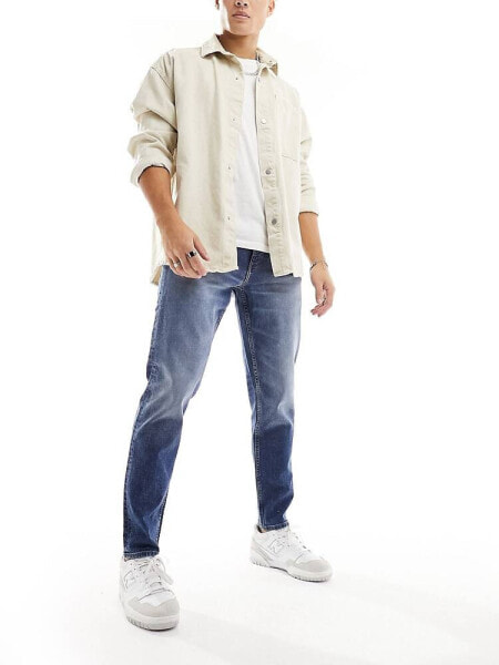 ASOS DESIGN tapered jeans in mid wash blue