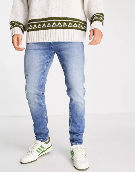 ASOS DESIGN skinny jeans in mid wash blue with abrasions