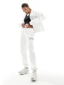 Купить женские брюки The Couture Club: The Couture Club co-ord varsity joggers in off white