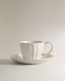 Stoneware teacup and saucer with raised design