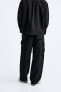 Creased-effect trousers with detachable detail