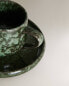 Green stoneware coffee cup and saucer