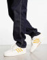 adidas Originals Rivalry Low trainers in white/gold