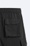 Creased-effect trousers with detachable detail
