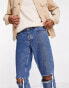 ASOS DESIGN tapered jeans in mid wash blue with knee rips