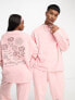 ASOS DESIGN – Locker geschnittene Unisex-Jogginghose in rosa Waschung mit Prints, Kombiteil