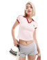 Motel – Isda – Knapp geschnittenes Poloshirt in Rosa mit Schleifenmotiv XS - EU36 - фото #1