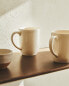 Earthenware mug with a raised-design edge