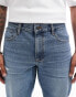 ASOS DESIGN tapered jeans with abrasions in midwash blue