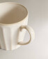 Stoneware mug with raised design