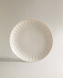 Stoneware dinner plate with raised design