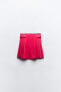 Box pleat mini skirt with buckles