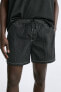 Swimming trunks with contrast topstitching