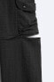 Creased-effect trousers with detachable detail