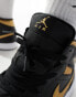 Air Jordan 1 mid trainers in black and gold