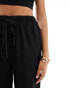 In The Style x Perrie Sian exclusive textured tie waist wide leg beach trousers in black