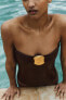 Swimsuit with a bandeau neckline and metal piece