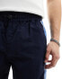 ASOS DESIGN baggy nylon track pants in navy with blue side stripe