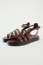 FLAT LEATHER SANDALS WITH CRISS-CROSS STRAPS