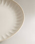 Stoneware dinner plate with raised design